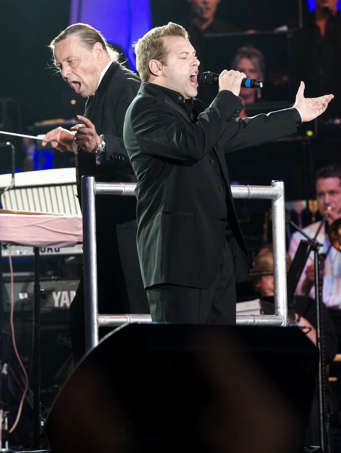 Christian Billett performing on stage with a live orchestra